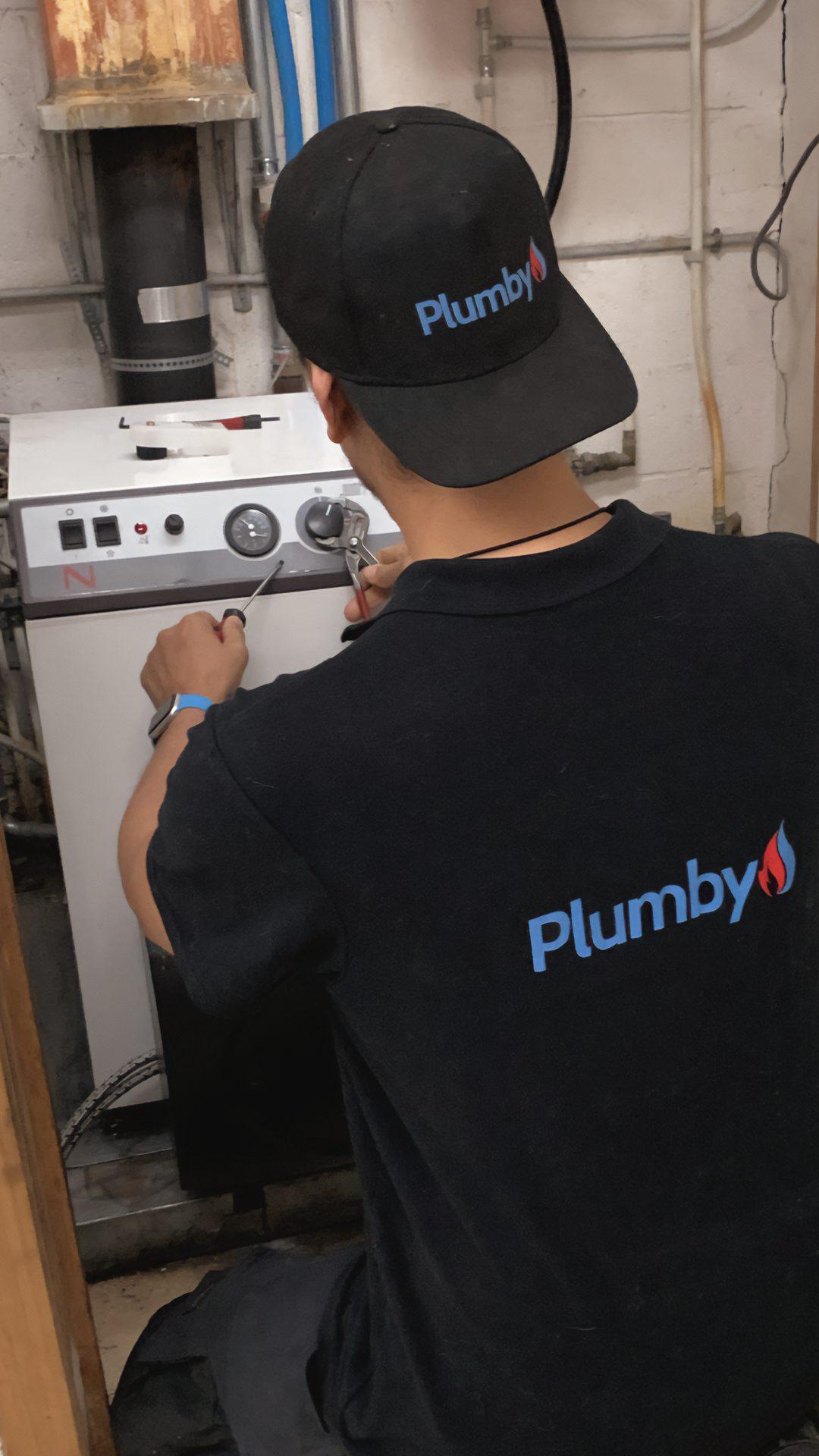 Technicien Plumby effectuant l'entretien d'une chaudiere
