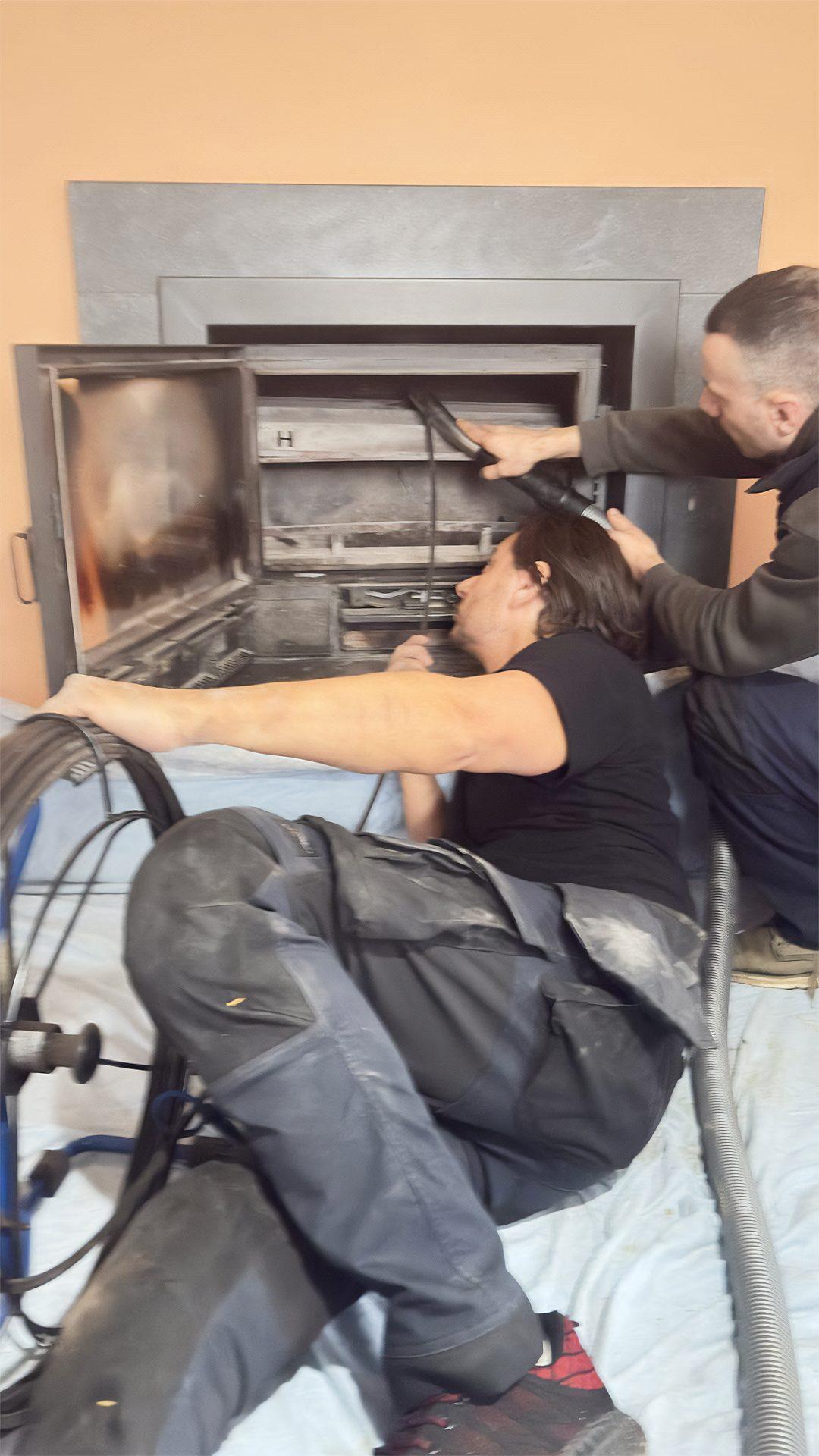 Equipe Plumby realisant le ramonage d'un insert de cheminee